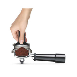 Mano sosteniendo un molinillo de café con Café molido fondo blanco.