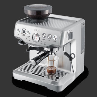Sage espresso machine with a glass of coffee on a black background
