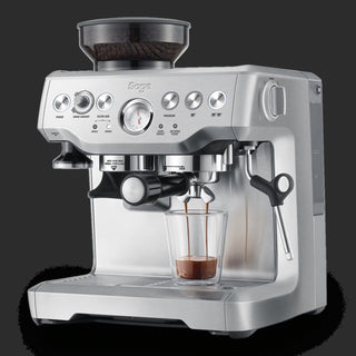 Silver Sage espresso machine with a glass of coffee on a black background