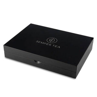 Caja cerrada de Semper Tea en elegante diseño negro con logo en la tapa.